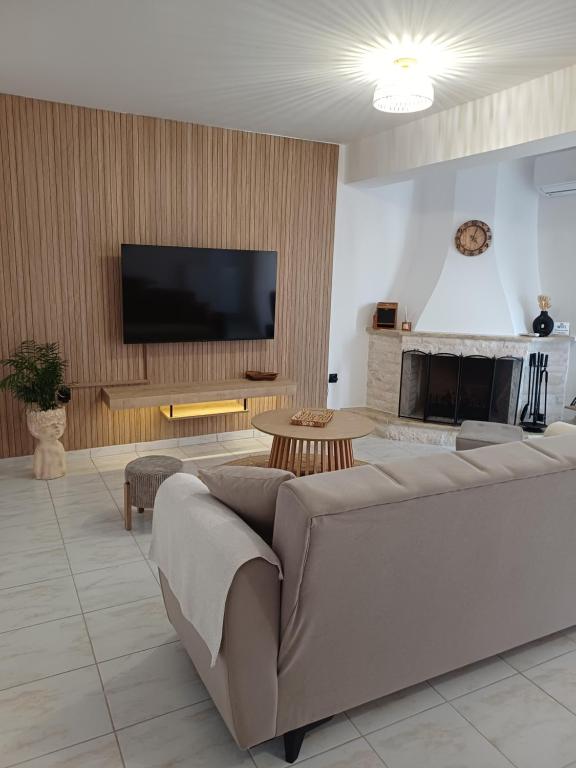 a living room with a couch and a flat screen tv at DANAI'S Sea Whisper in Lékhaion