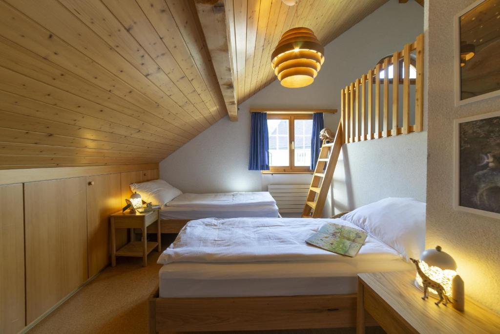 a attic room with two beds and a staircase at Dachnest in Unterwasser