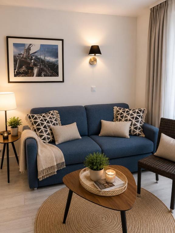 a living room with a blue couch and a table at Antibes Port - Terrasse - Parking - Piscine in Antibes