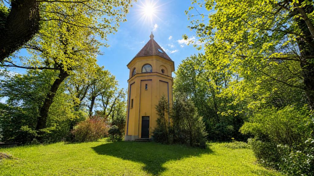a tower in the middle of a field with trees at Wasserturm Putbus in Putbus
