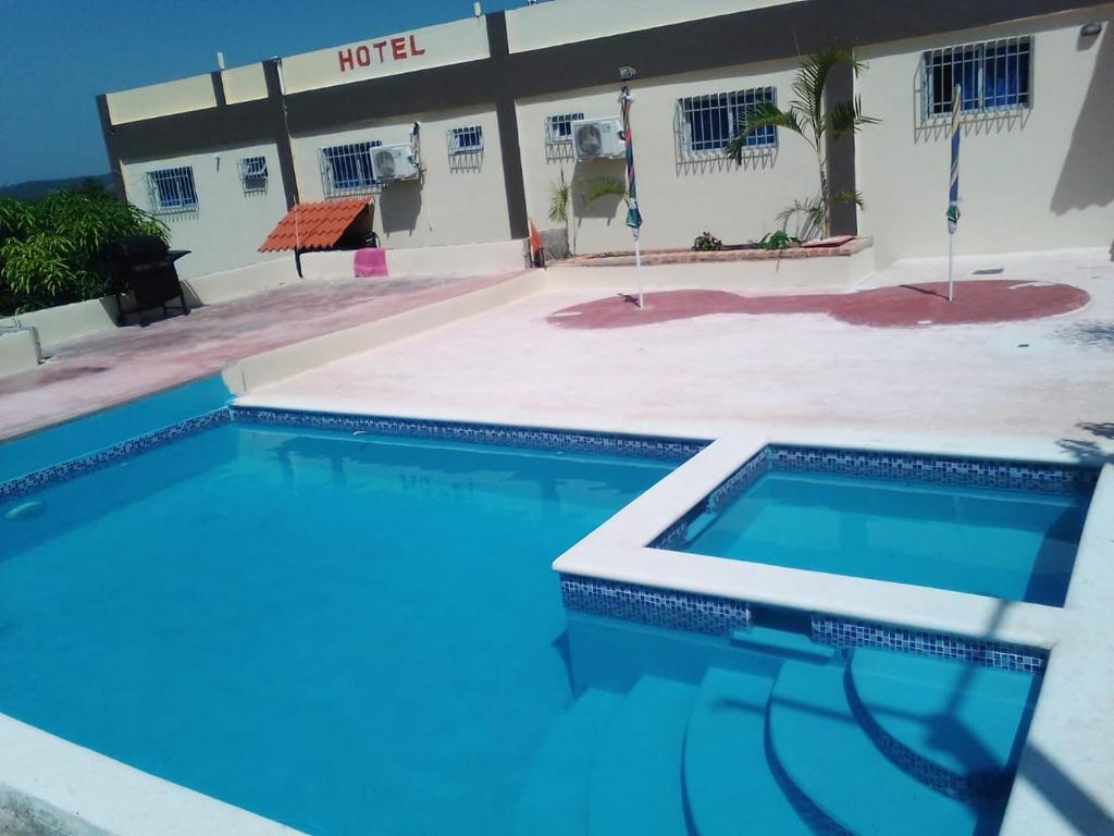 a swimming pool in front of a hotel at Hotel Rosangel in Estero Hondo