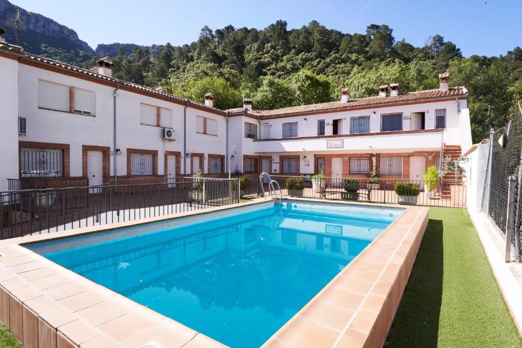 a villa with a swimming pool in front of a building at ESTRELLA de la SIERRA in Arroyo Frio