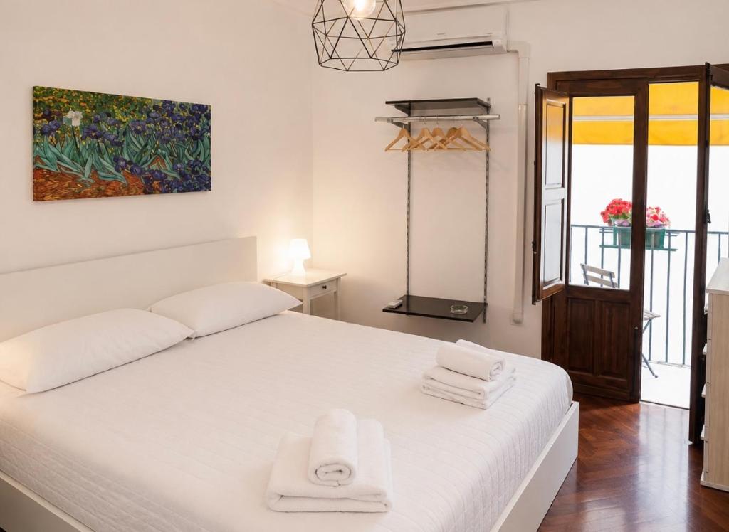 a bedroom with a white bed with towels on it at Centro A Casuzza in Palermo
