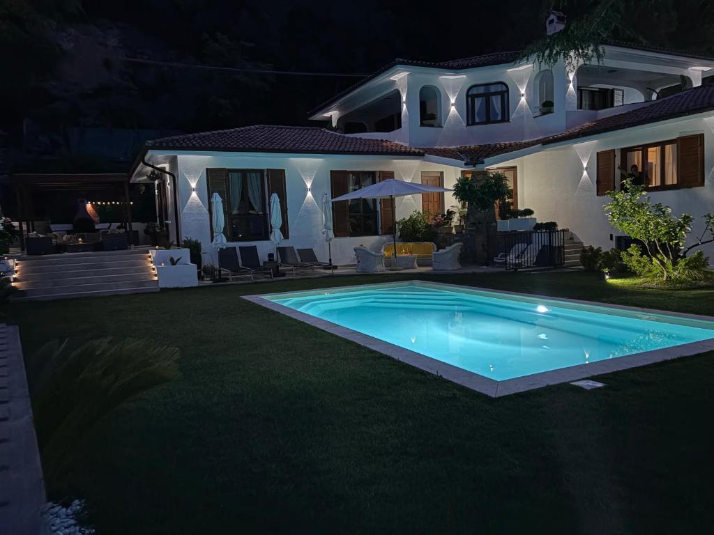 a house with a swimming pool at night at VILLA ROMA Resort in Vallecrosia