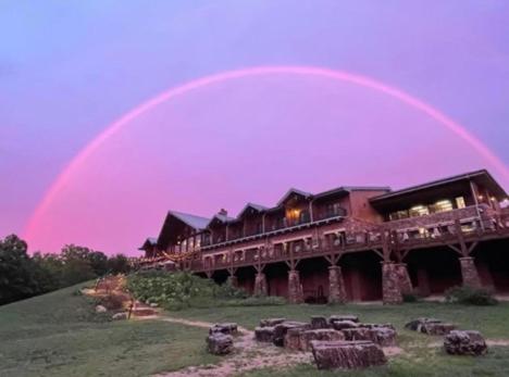 a rainbow in the sky above a building at Echo Bluff State Park Lodge and Cabins in Eminence