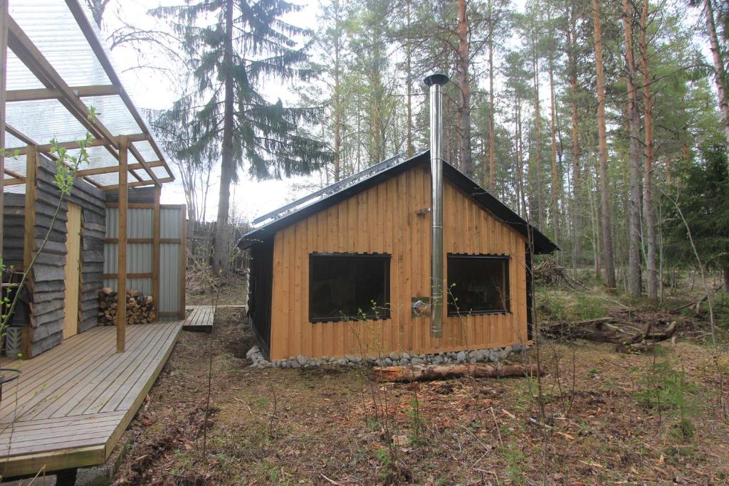 a small wooden cabin with a porch and a deck at Forest Shed in Åsele