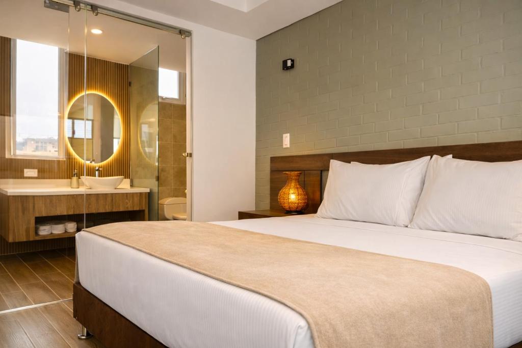a bedroom with a large bed and a bathroom at Lago Verde Elit in Paipa