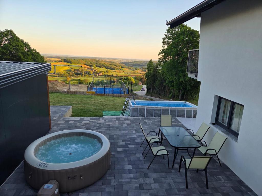 a hot tub on a patio with a table and chairs at Vacation home Vilim in Kamešnica
