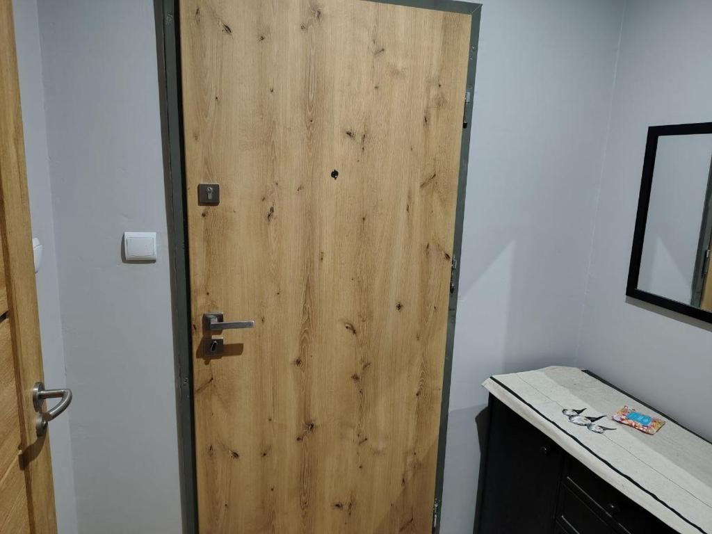 a wooden door in a room with a desk at Chelm Spoko Apartment in Chełm