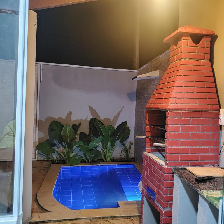 a patio with a brick oven in a garage at Casinha Larithur in Beberibe