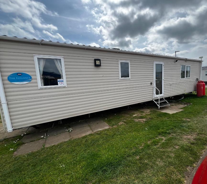 a mobile home with the door open in a yard at California cliffs caravan in Great Yarmouth