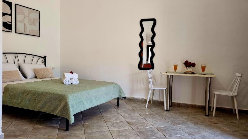 a bedroom with a bed and a table with two chairs at Studio Marianna & George in Plátanos