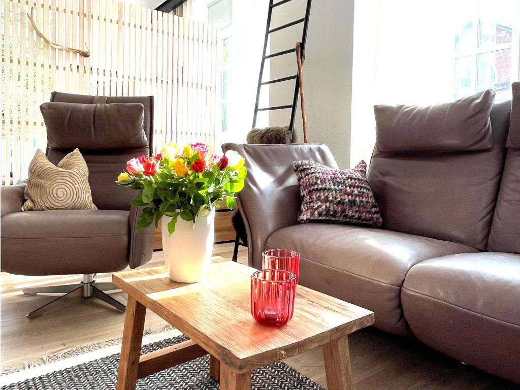 a living room with a couch and a table with flowers at Thüringer Wald-Zauber in Zella-Mehlis
