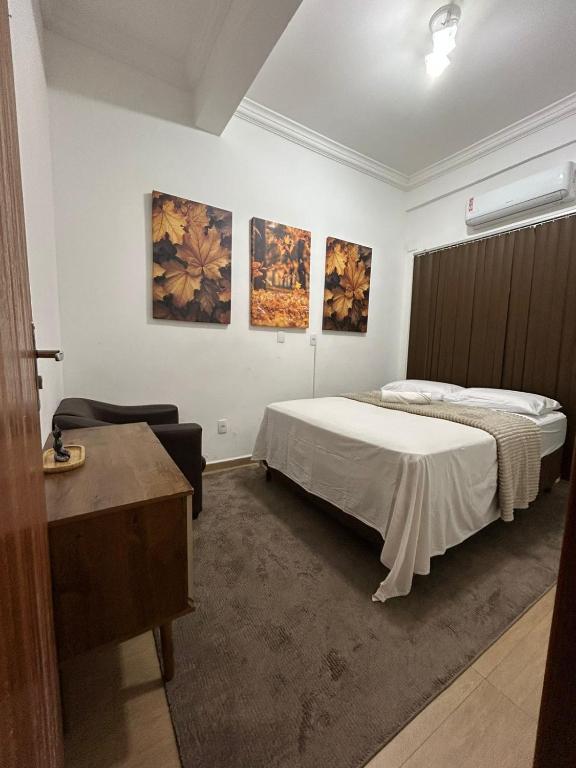 a bedroom with a bed and paintings on the wall at Espaço Physis in Vila Velha
