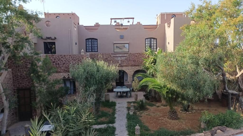 an exterior view of a building with a garden at le petit yucca - chambre groovy in Tiznit