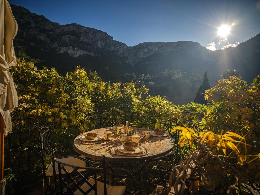 a table with cups and plates on it with a view at C'AN Sabuba in Deia