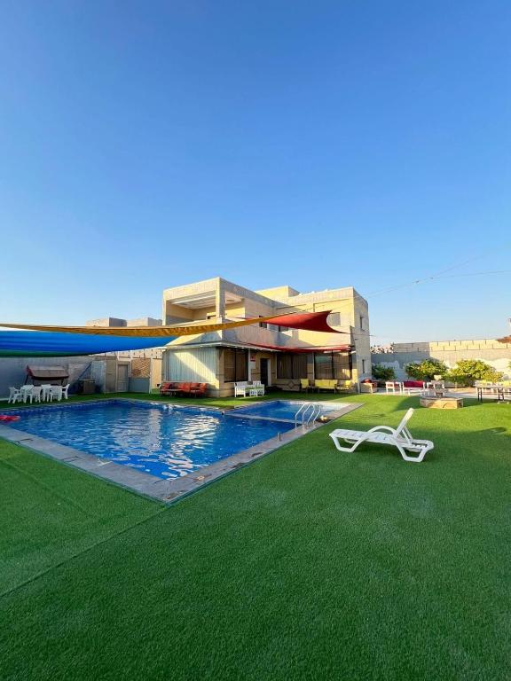 a building with a swimming pool in front of a building at Al Salty in Tall ar Rāmah
