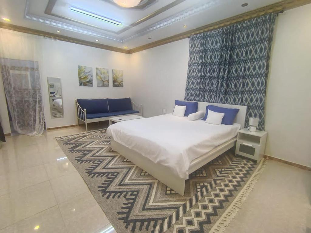a bedroom with a large white bed and a rug at الينبوع الأخضر in Medina