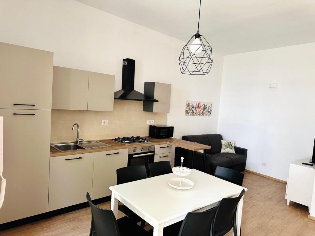 a kitchen and living room with a white table and chairs at Casa Lucia in Marta