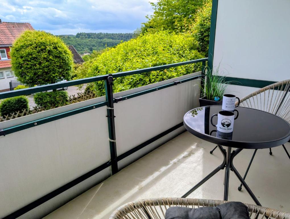 a balcony with a table and chairs and a view at MeLou Fewo Harzruhe Wellness in Bad Lauterberg