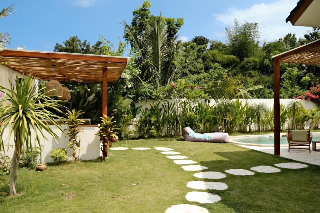 a backyard with a swimming pool and a garden at Promo - Private 1BR villa for couples in Kuta Lombok