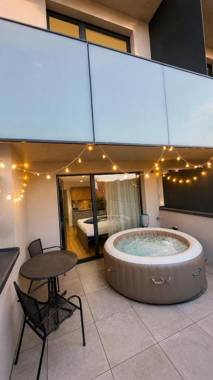 a hot tub in a room with a table and a bed at AH Terrace Jacuzzi Suite near Arena in Košice