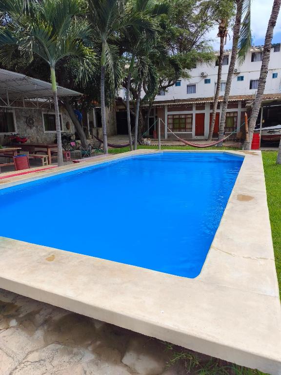 a large blue swimming pool in front of a building at Stone House Mancora in Máncora