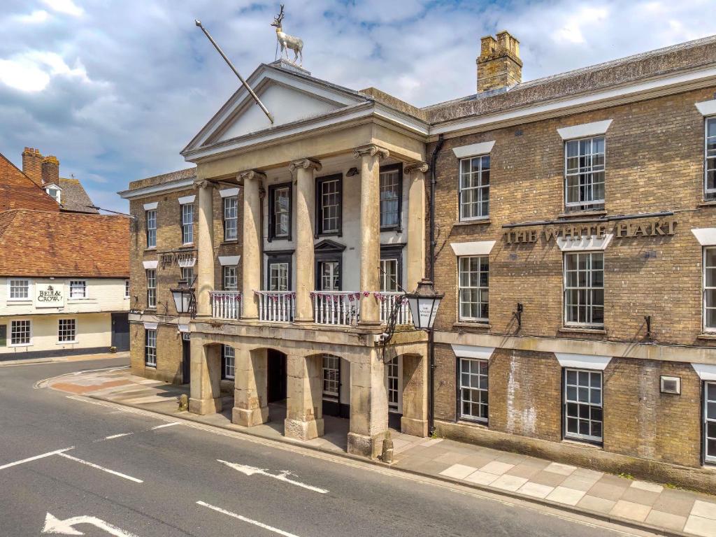 a large brick building with a balcony with a goat on the roof at Mercure Salisbury White Hart Hotel & Apartments in Salisbury