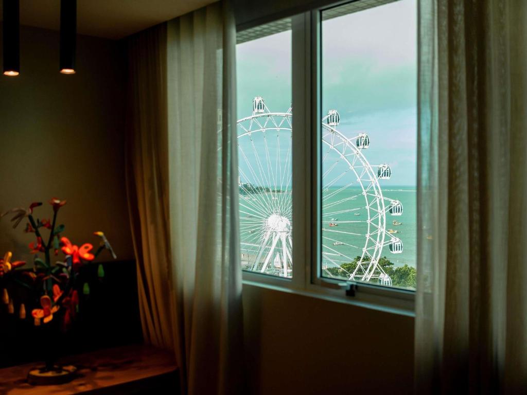 a view of a ferris wheel from a window at Mercure Maceio Pajuçara in Maceió