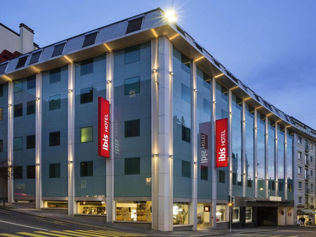 a building with red signs on the side of it at ibis Lausanne Centre in Lausanne