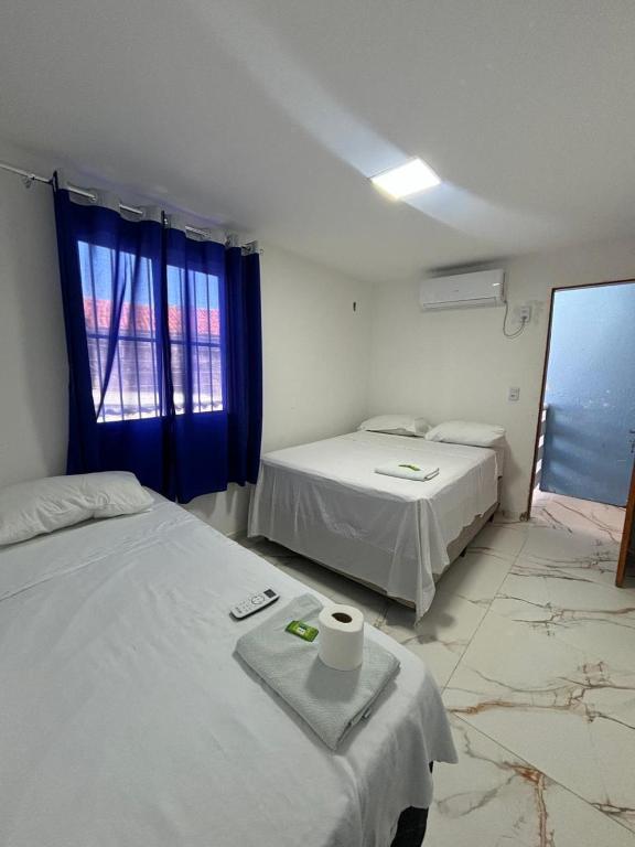 a room with two beds and a window at Pousada Sol Brasil in Fortaleza