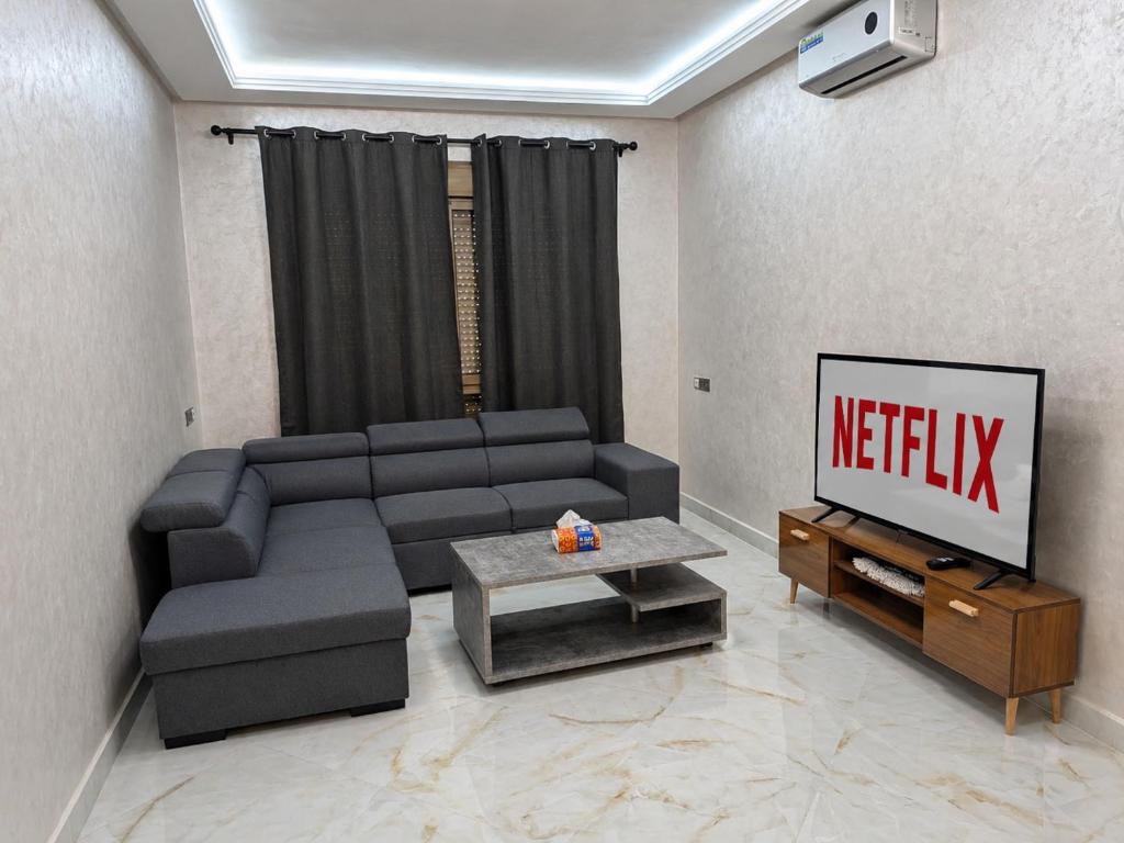 a living room with a couch and a television at Brand new apartment in Sport city Tangier in Tangier