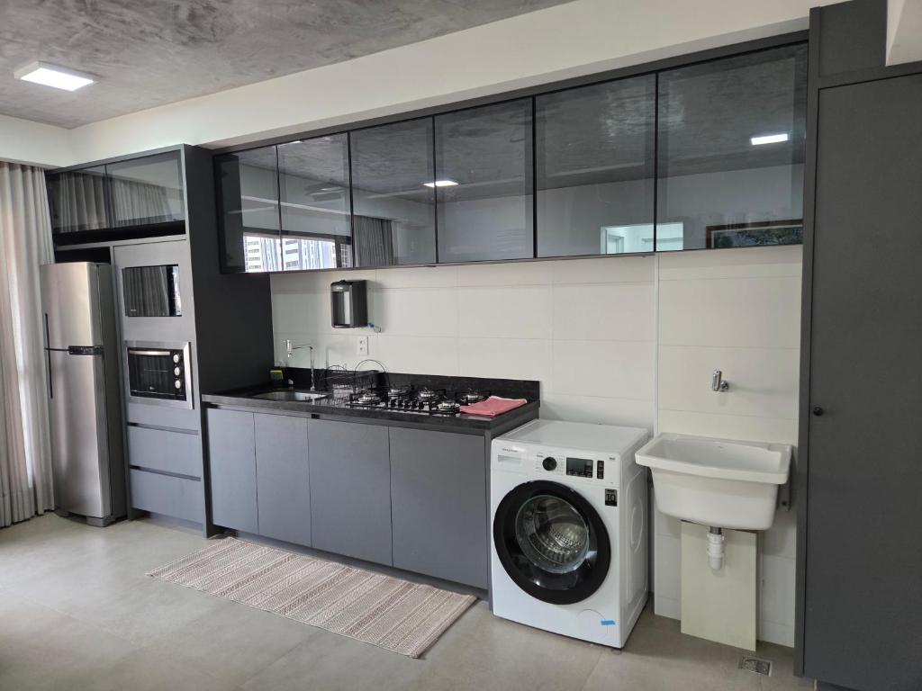 a kitchen with a washing machine and a washer at Apartamento espaçoso de luxo in Goiânia