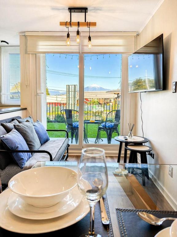 a living room with a table with a wine glass at Departamento Villarrica Vista al Volcán y Piscina in Villarrica