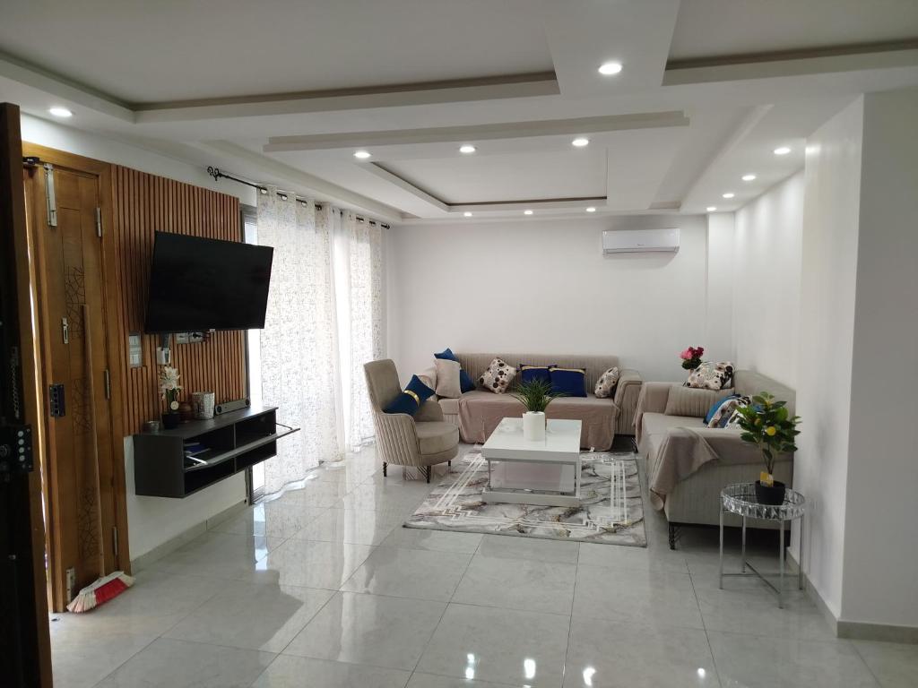 a living room with a couch and a tv at Tawfik in Midoun