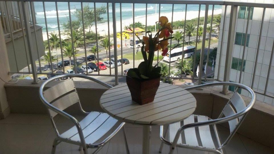 una mesa y sillas con una maceta en el balcón en Apartamento Barra da Tijuca com vista espetacular, en Río de Janeiro