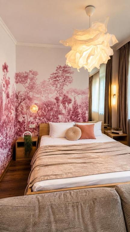 a bedroom with a large bed with a pink wall at Central City Balcony Apartments in Mukacheve