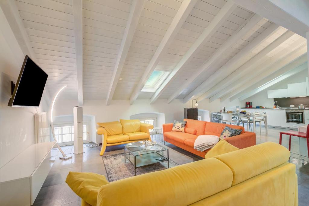 a living room with two couches and a tv at Loft & Jacuzzi - Happy Rentals in Riva del Garda