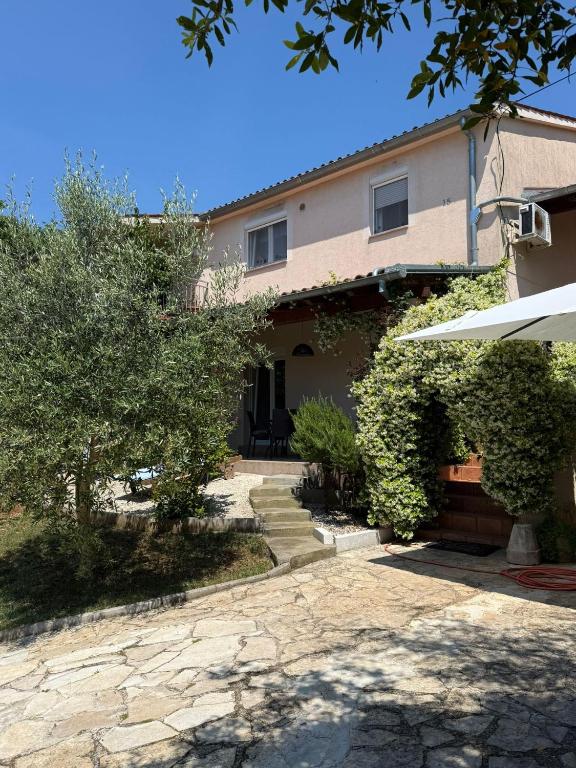 a house with a stone driveway in front of it at Apartman Ilaria in Medulin