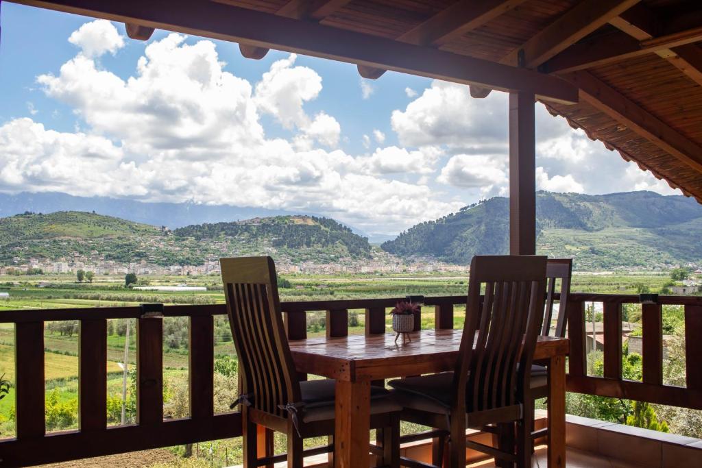 a table and chairs on a porch with a view of mountains at CASTLE View SERENITY -- BERAT in Berat
