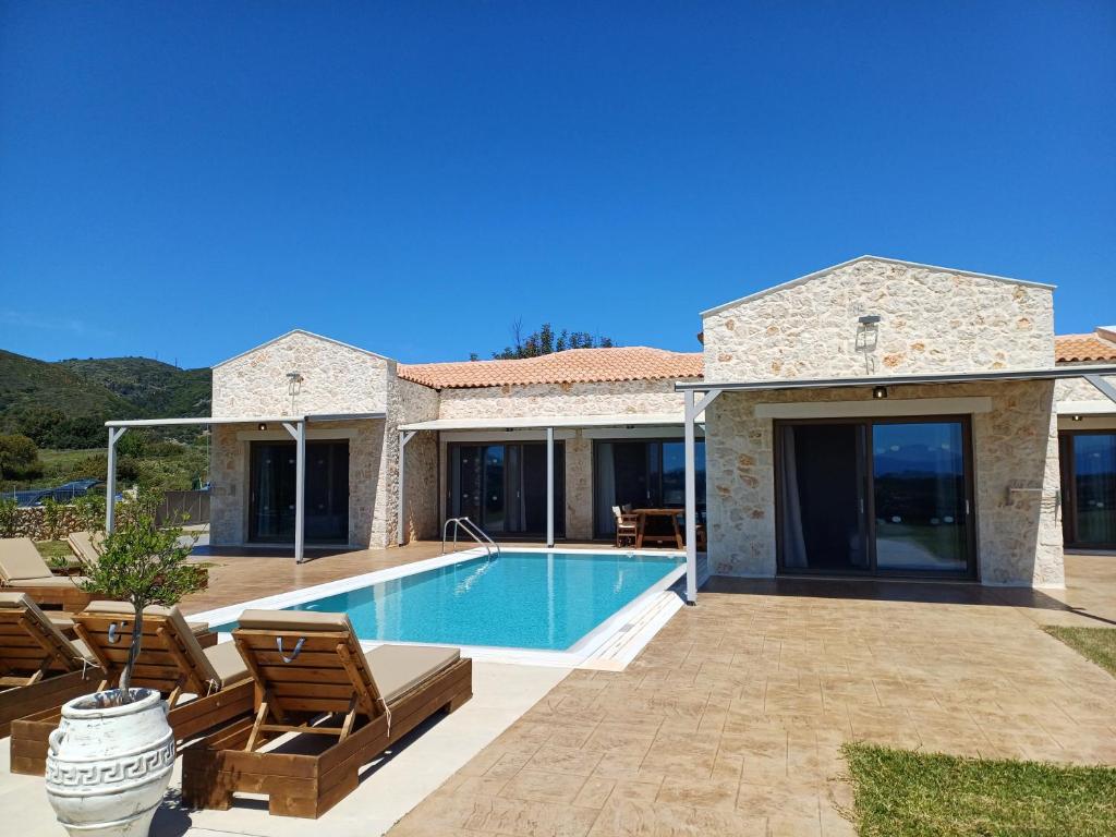 a villa with a swimming pool and a house at Pantheon Luxury Villas in Skala