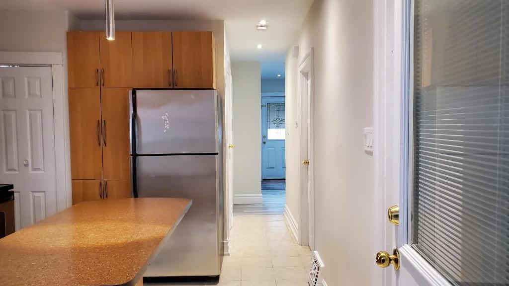 a kitchen with a stainless steel refrigerator and a hallway at House - Bungalow in Hamilton