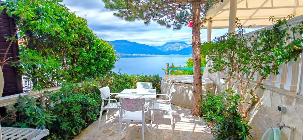 a patio with a table and chairs and a view of the water at Boka Apartments in Tivat