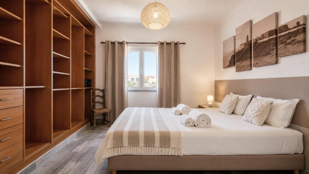 a bedroom with a large bed and a window at Tonel Apartments in Sagres