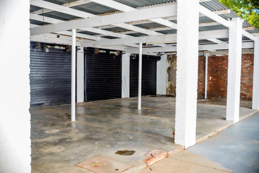 an empty parking lot with black garage doors at Makay's Guests House in Kimberley
