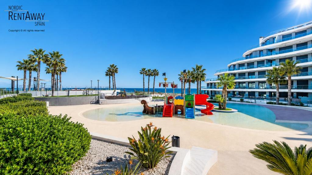 a resort pool with a playground and a building at Infinity View Apartments by NRAS in Arenales del Sol