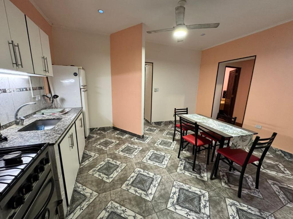 a kitchen with a table and chairs and a refrigerator at Fortunata Urban in San Miguel de Tucumán