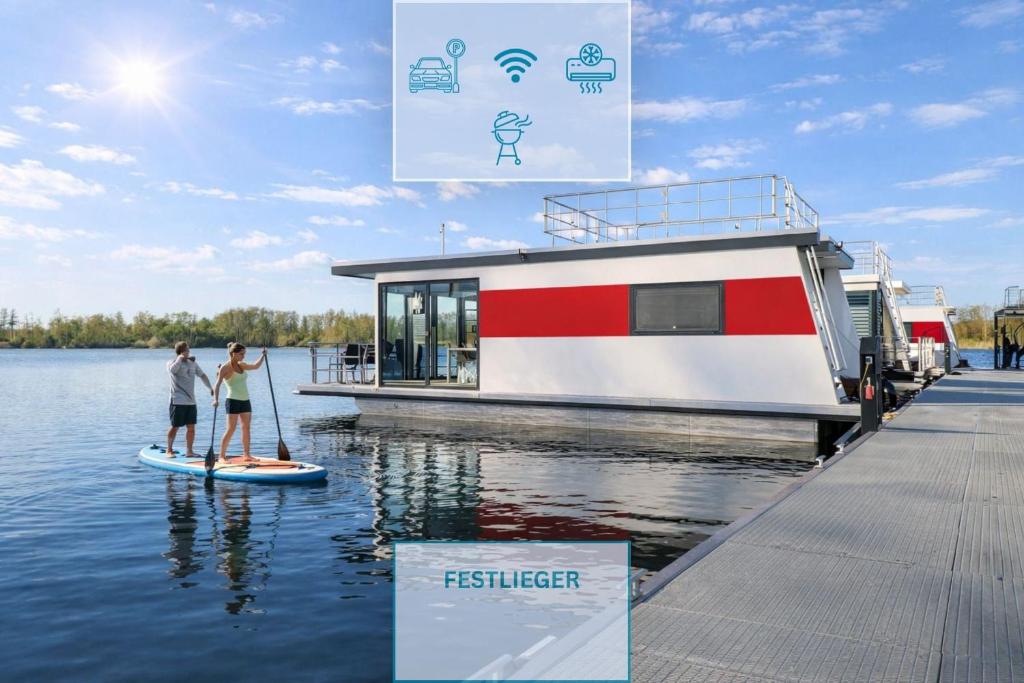 two people on a paddle board in front of a boat at Floatinghouse Achat in Zehdenick