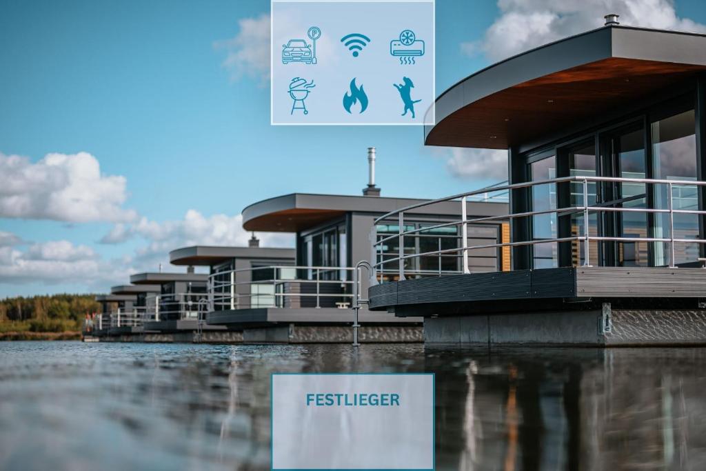 a building with a sign in front of a body of water at Floatinghouse Heaven on Earth in Klitten