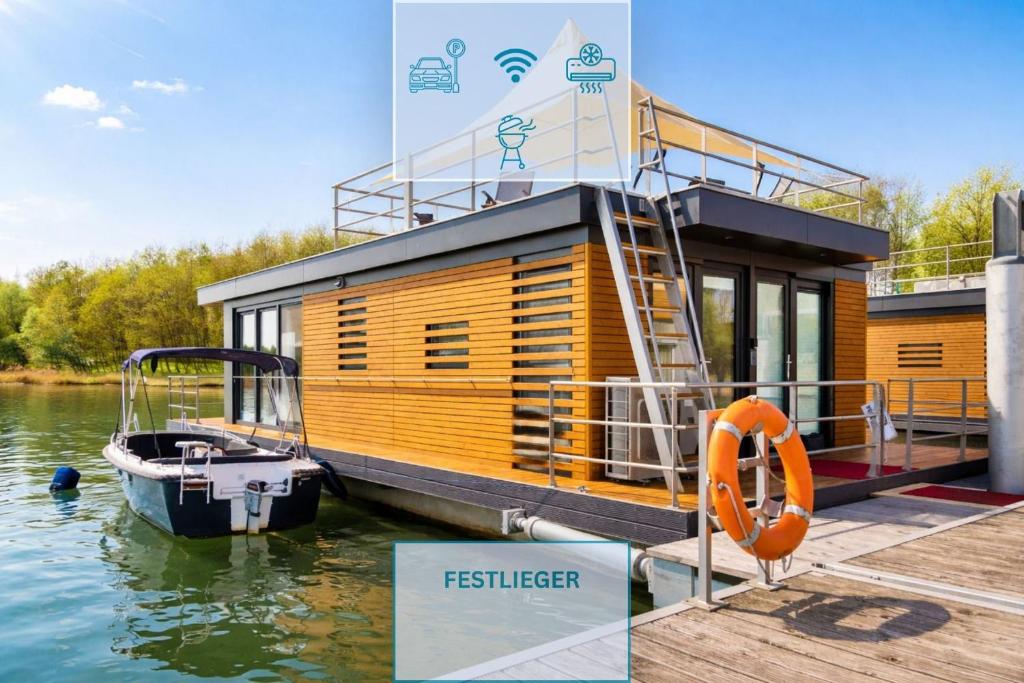 a small wooden boat is docked at a dock at Floatinghouse Möwe 2 - LP2 in Vetschau